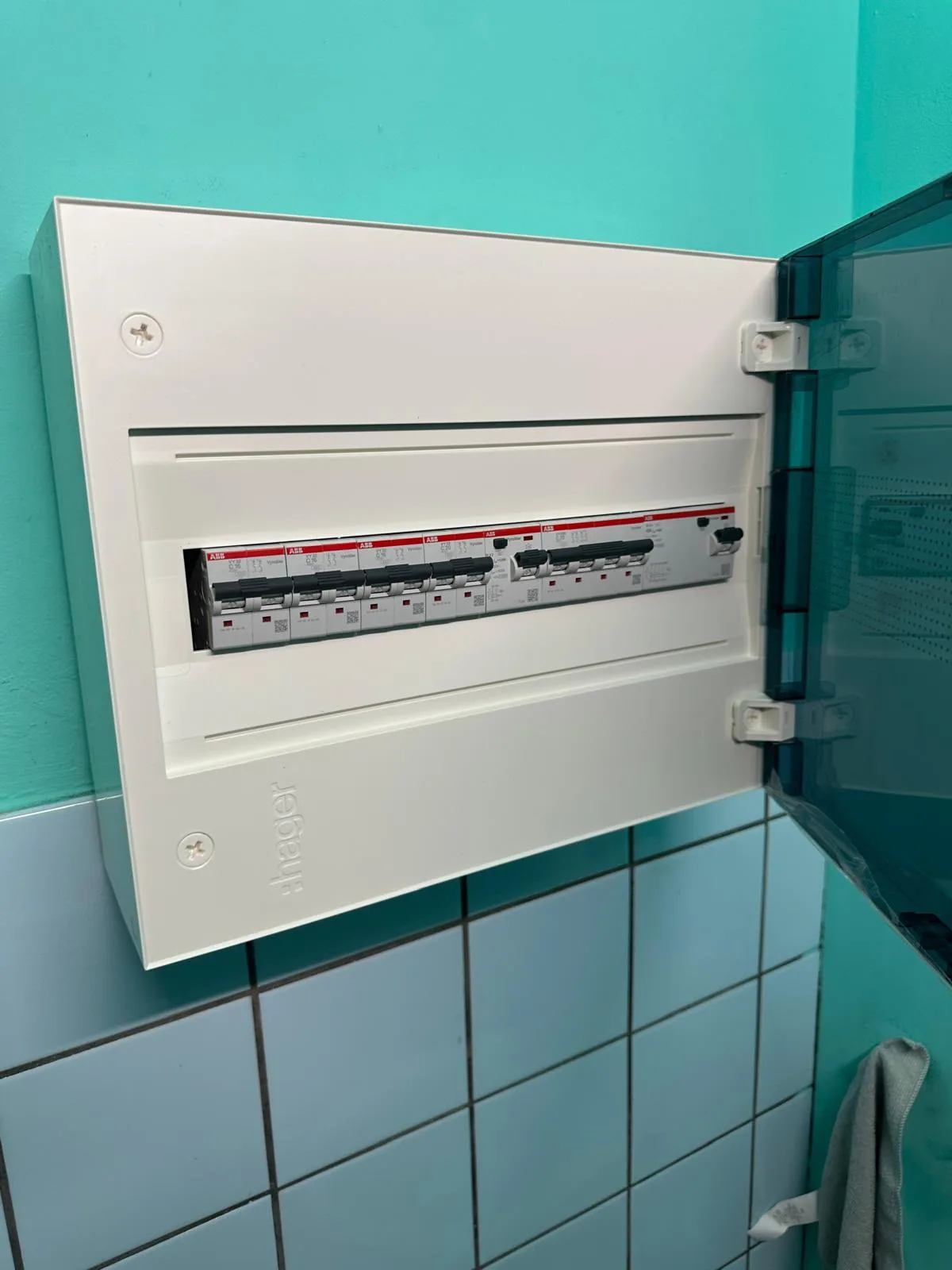 Nieuw compact verdeelbord met automaten en een differentieelschakelaar op een turquoise muur