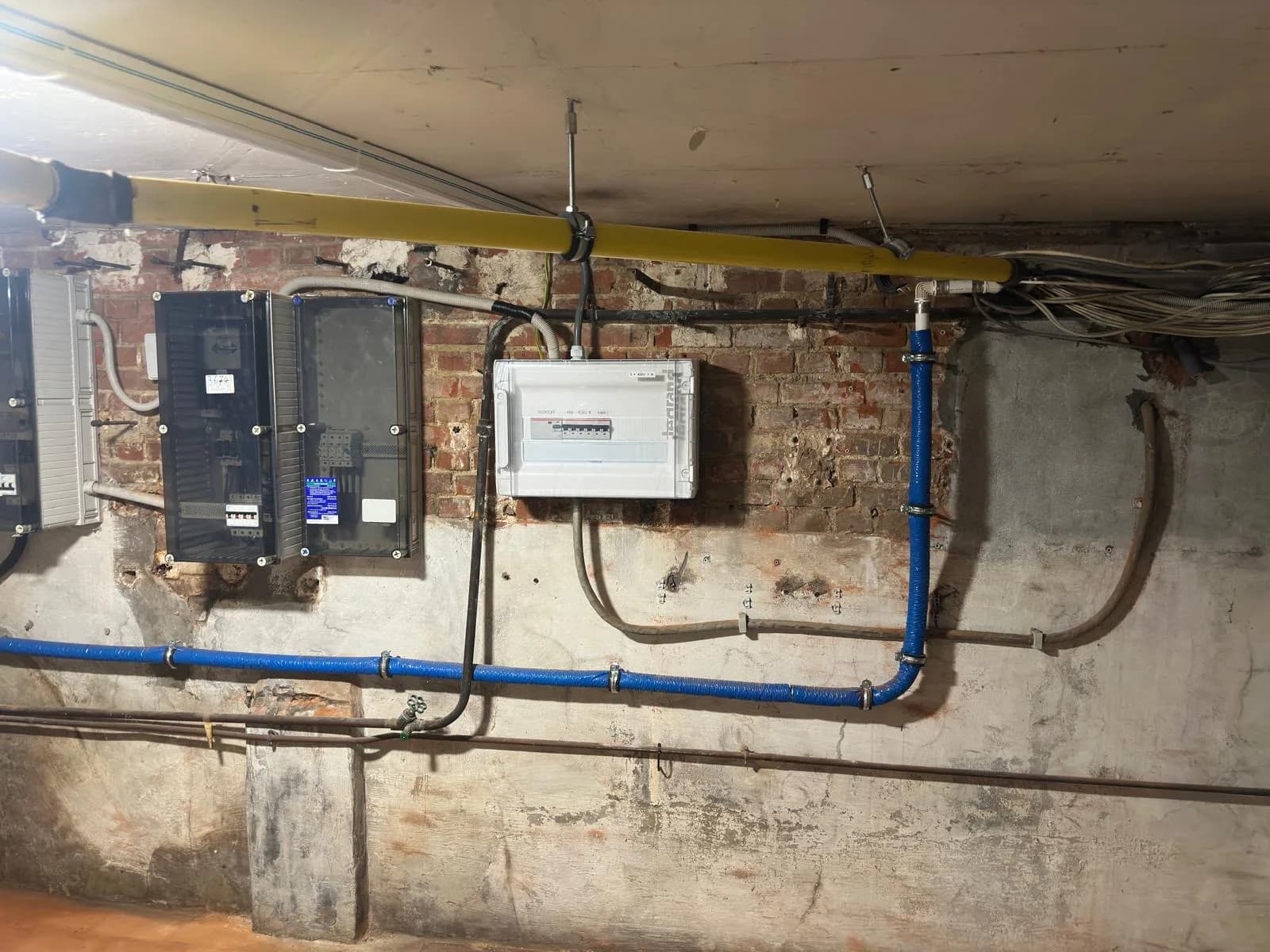Kelder met de tellerkast en een nieuw verdeelkastje van 3 x 400 V op de bakstenen muur